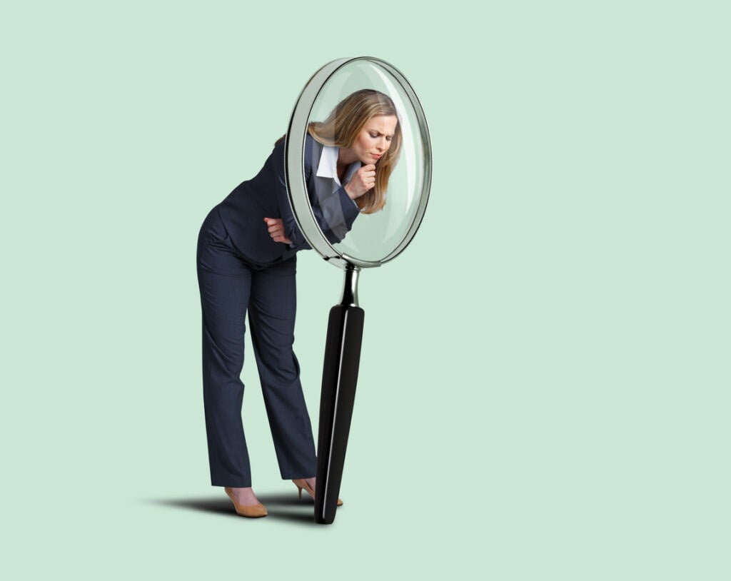 Businesswoman Looking Through Large Magnifying Glass